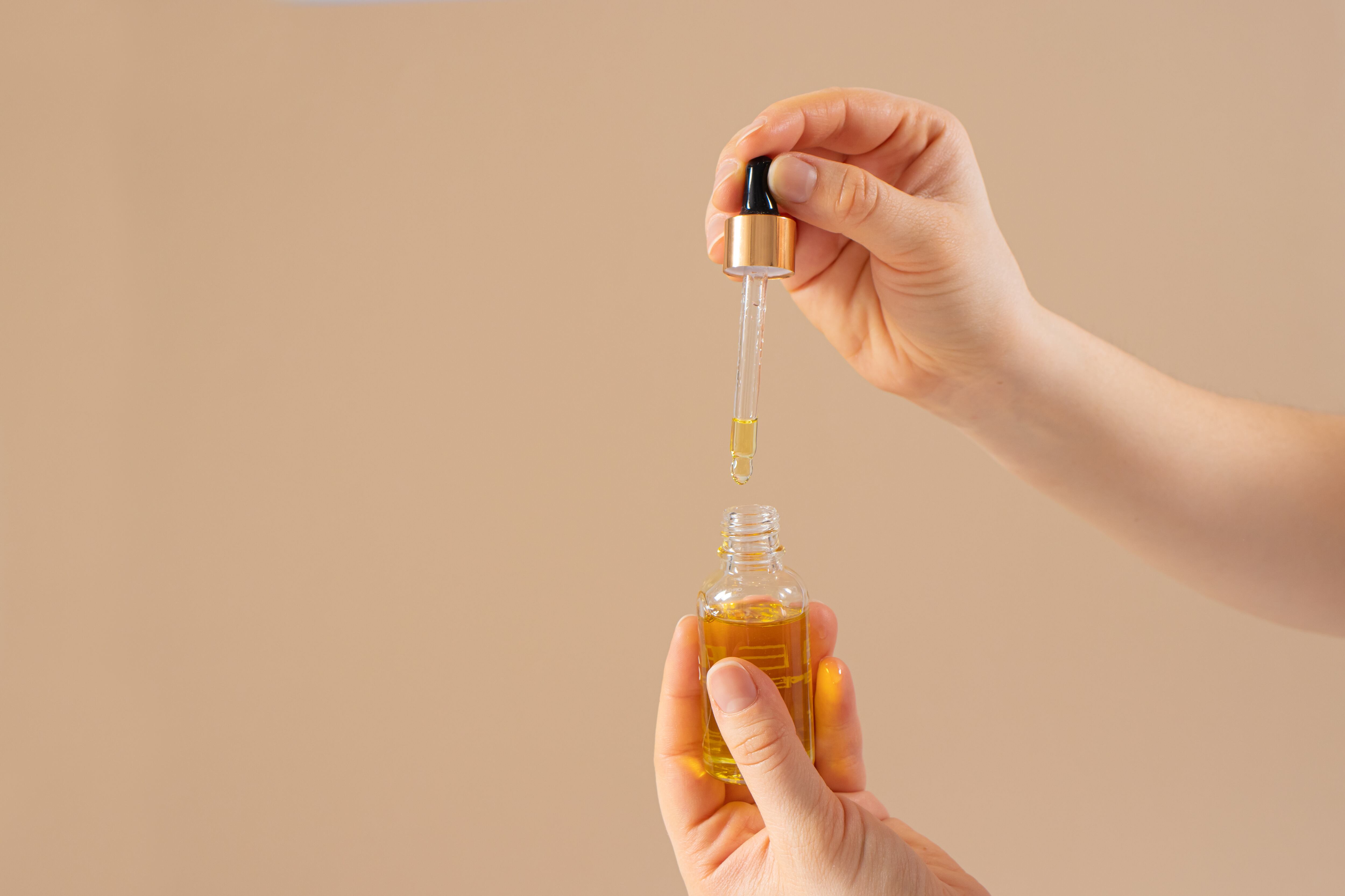 Aceite de ricino para pestañas y cejas para el crecimiento del cabello en un frasco de vidrio con un cuentagotas.