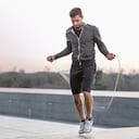 Hombre adulto medio, al aire libre, saltando con la cuerda