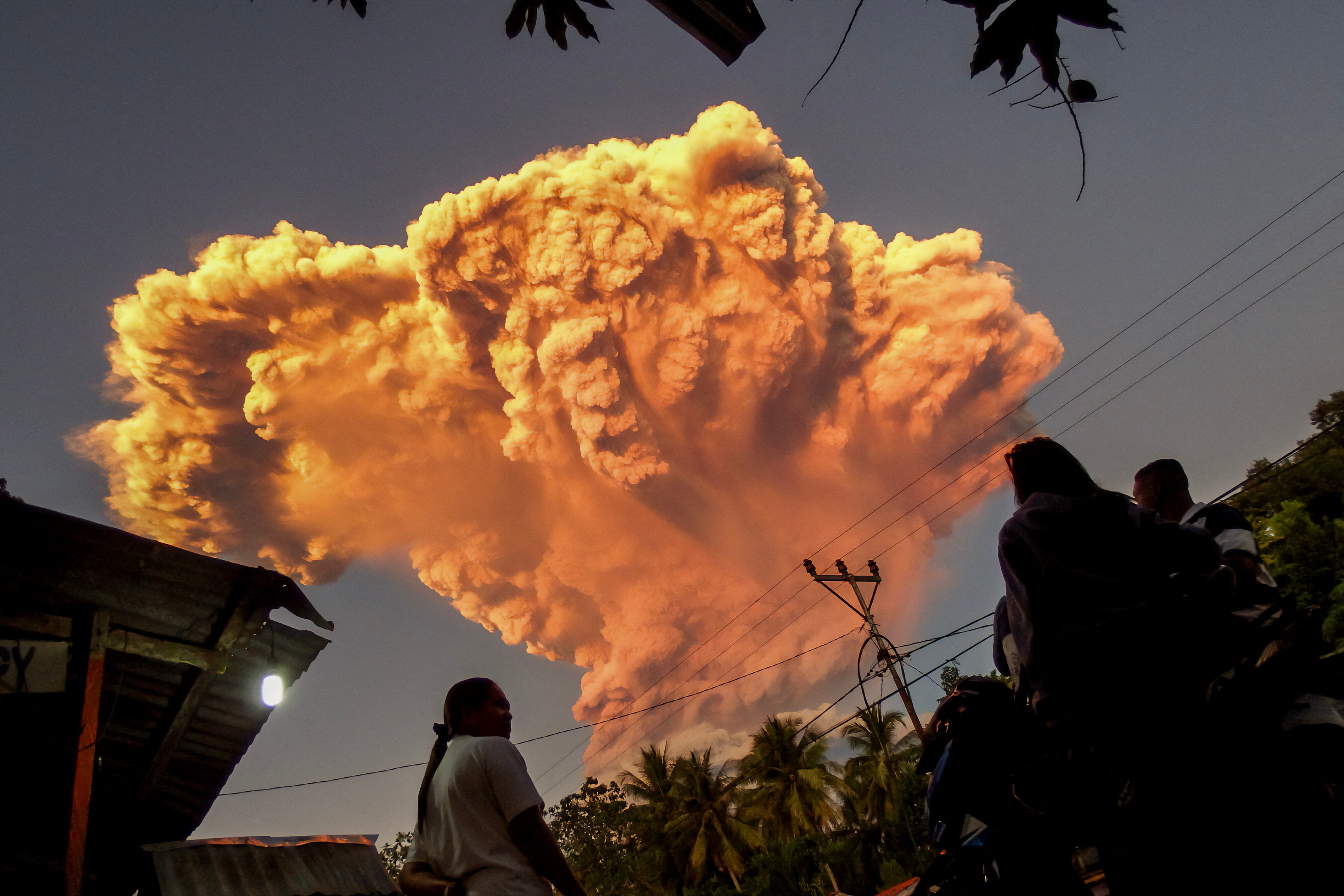 Los aldeanos observan la erupción del monte Lewotobi Laki-Laki desde la aldea de Talibura en Sikka, Nusa Tenggara Oriental, el 17 de junio de 2025. Un volcán en el este de Indonesia expulsó una colosal torre de ceniza el 17 de junio, según informaron las autoridades, tras elevar su nivel de alerta al máximo de un sistema de cuatro niveles. (Foto de AFP)