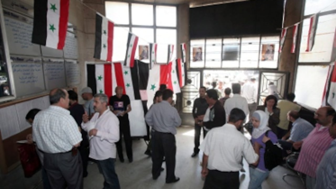 Varios ciudadanos sirios congregados en un colegio electoral de Damasco.