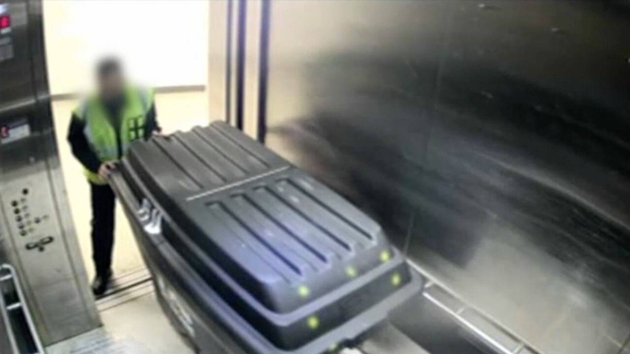 Momento en el que el operario de aseo saca a los migrantes en el carro de basuras.