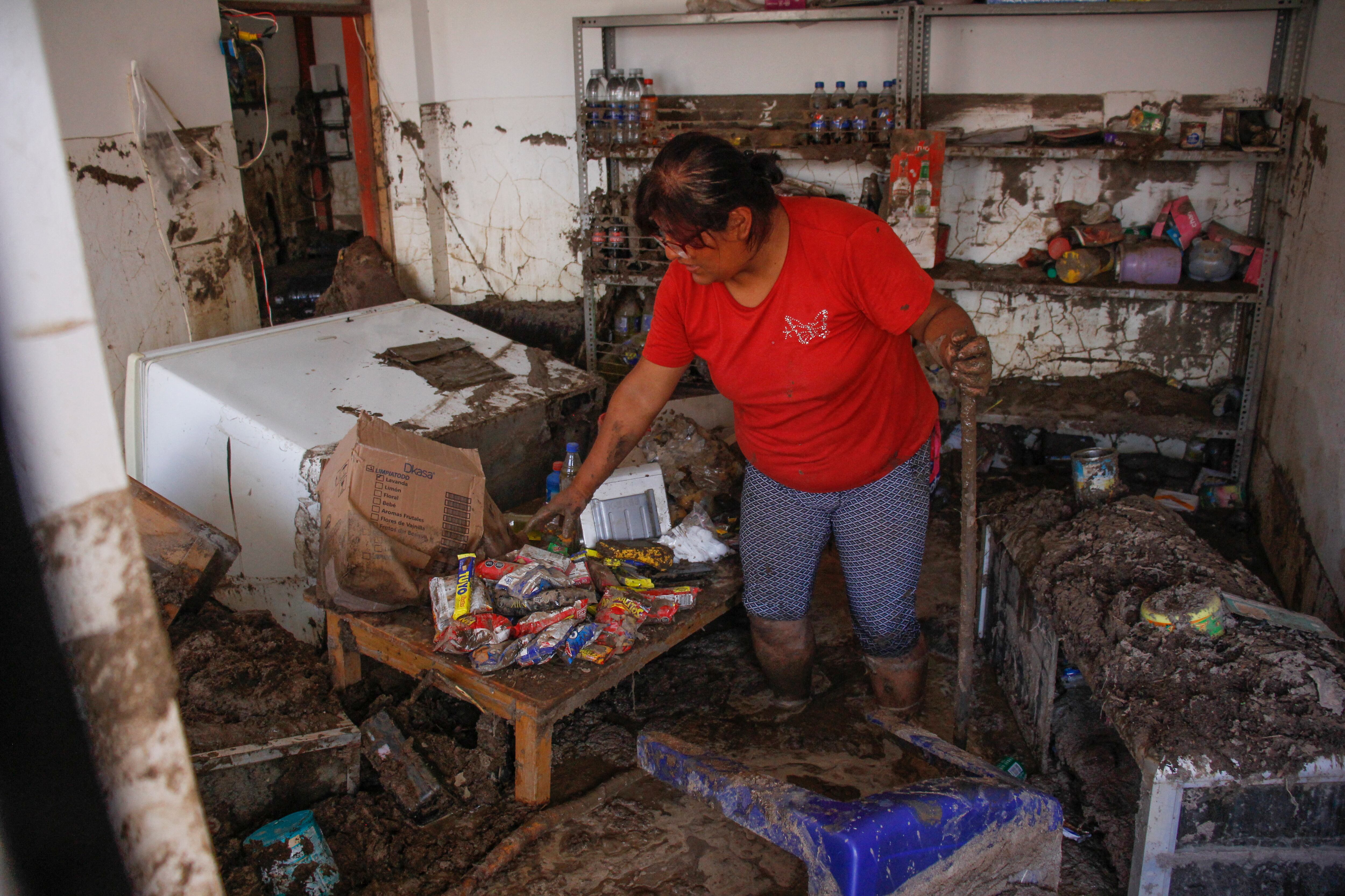 Una residente del distrito semirrural de La Esperanza, al norte de Trujillo en el departamento de La Libertad, Perú, retira lodo y escombros de su casa el 13 de marzo de 2023, luego de las fuertes lluvias provocadas por el ciclón Yaku. - Al menos 59 muertos y más de 12.000 personas sin hogar han dejado la temporada de lluvias en Perú desde septiembre por inundaciones y desbordamiento de ríos, informó el 12 de marzo la Defensa Civil. Las inundaciones acompañadas de fuertes vientos que afectan a parte de Perú aumentaron en los últimos 72 horas y afectó zonas urbanas y rurales de los departamentos costeros de Ancash, La Libertad, Lambayeque, Piura y Tumbes, cercanos a la frontera con Ecuador. (Foto por Arturo GUTARRA / AFP)