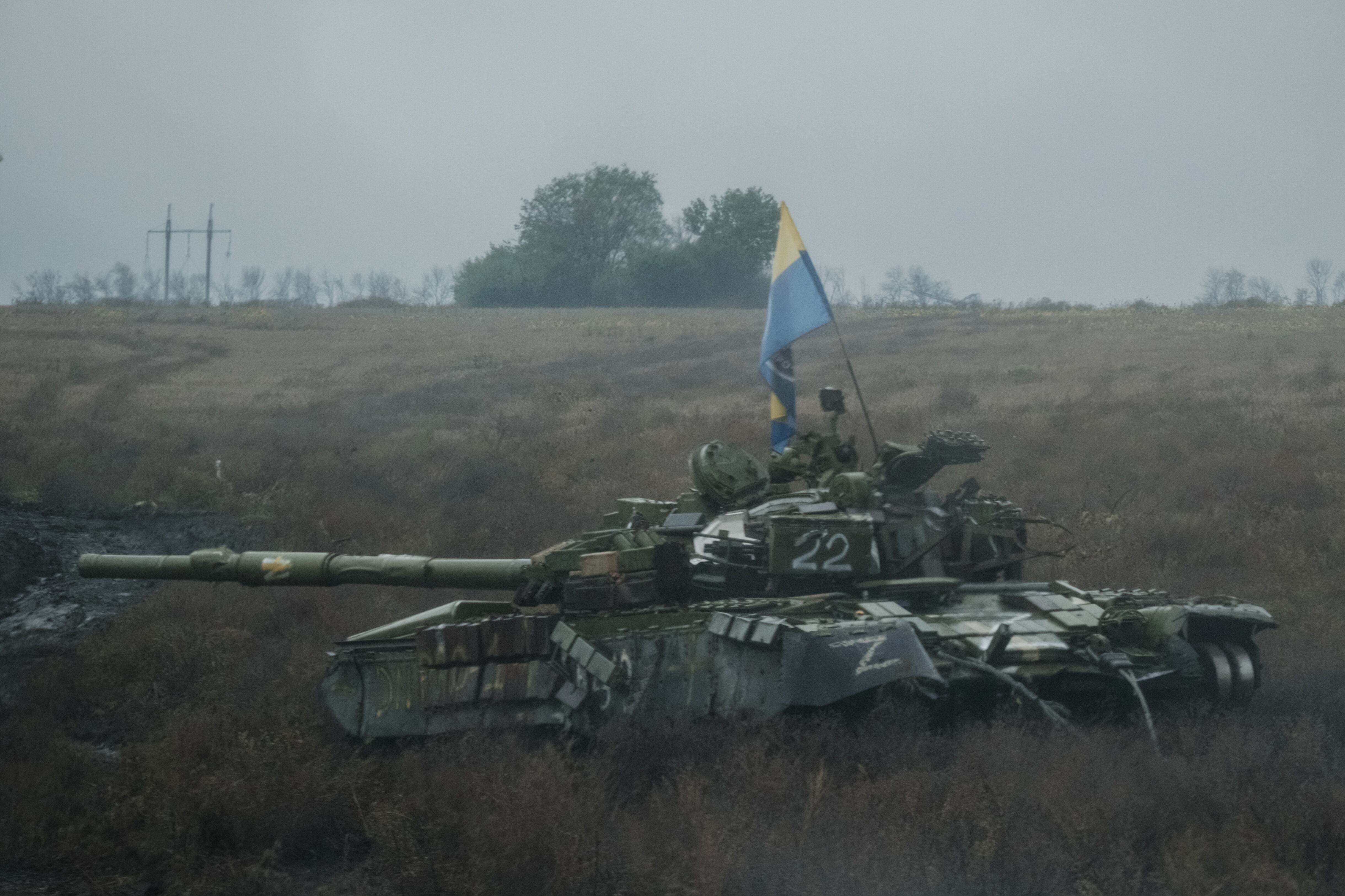 Se coloca una bandera ucraniana en un tanque ruso abandonado cerca de Dolina en la región de Donetsk, el 10 de octubre de 2022, en medio de la invasión rusa de Ucrania. (Foto de Yasuyoshi CHIBA / AFP)