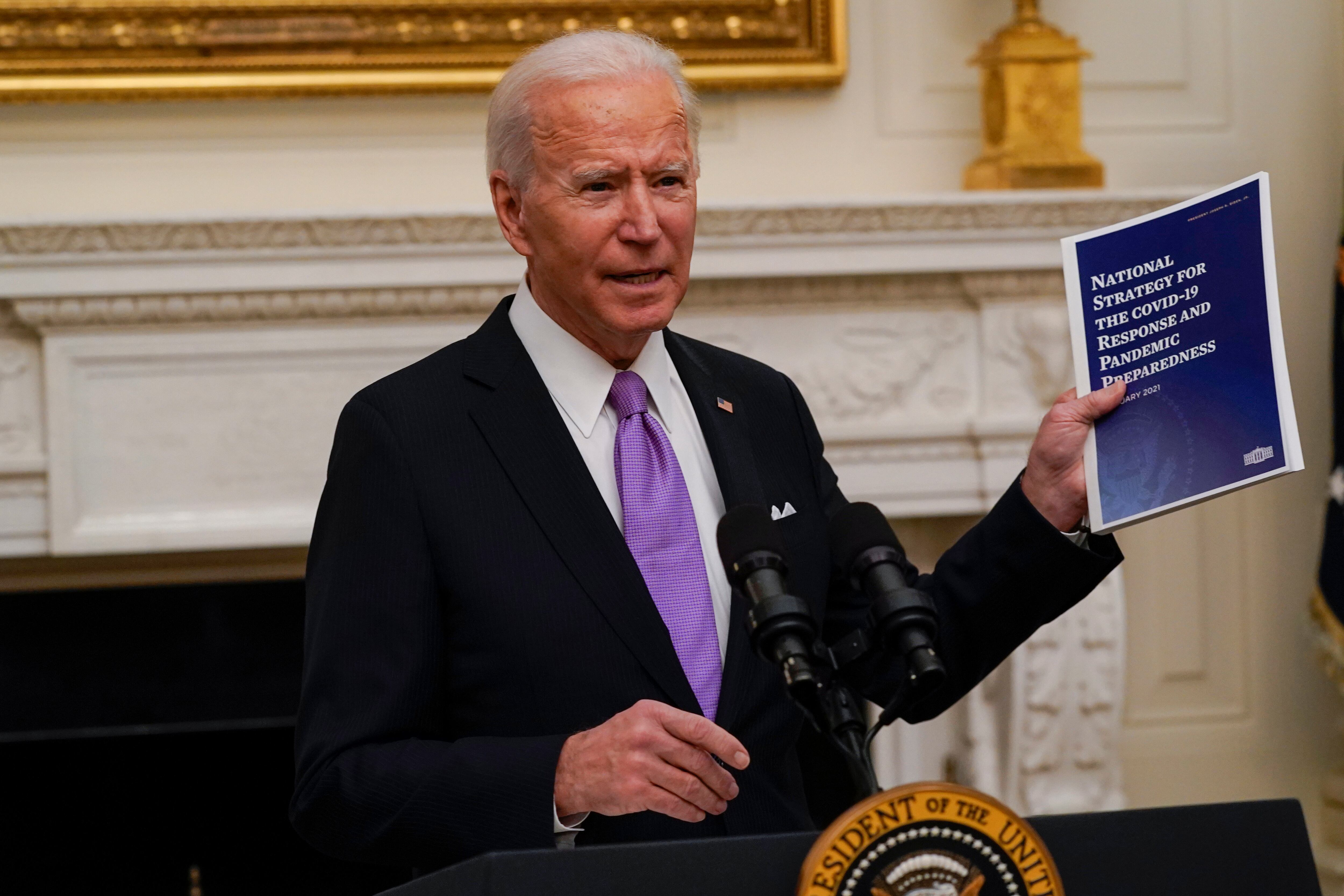 President Joe Biden holds a booklet as he speaks about the coronavirus in the State Dinning Room of the White House, Thursday, Jan. 21, 2021, in Washington. (AP Photo/Alex Brandon)