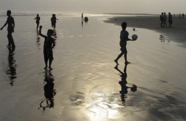 Algunas personas juegan en la playa en la Bahía de Bengala, en Birmania. (AP)