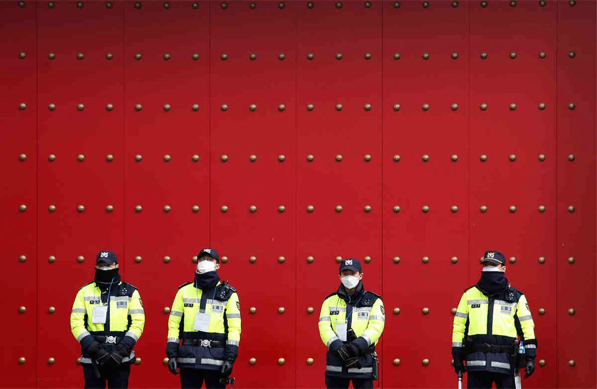 Oficiales de policía hacen guardia, mientras los manifestantes organizan un mitin pidiendo la prohibición de la entrada de chinos a Corea del Sur, el 4 de febrero de 2020. El número de muertos en China ya ha aumentado a 425. Foto: Ahn Young-joon/ AP.