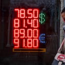 Una mujer pasa junto a una casa de cambio en la que se ve la tasa de cambio del dólar americano y el euro con respecto al rublo ruso. Moscú, 22 de febrero de 2022. Foto: Dimitar Dilkoff / AFP