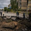 Los residentes locales examinan un cráter luego de un ataque con misiles en Dnipro el 10 de octubre de 2022, en medio de la invasión rusa de Ucrania. - El jefe del ejército ucraniano dijo que las fuerzas rusas lanzaron al menos 75 misiles contra Ucrania el lunes por la mañana, con ataques fatales contra la capital, Kyiv, y ciudades en el sur y el oeste. (Foto de Dimitar DILKOFF / AFP)