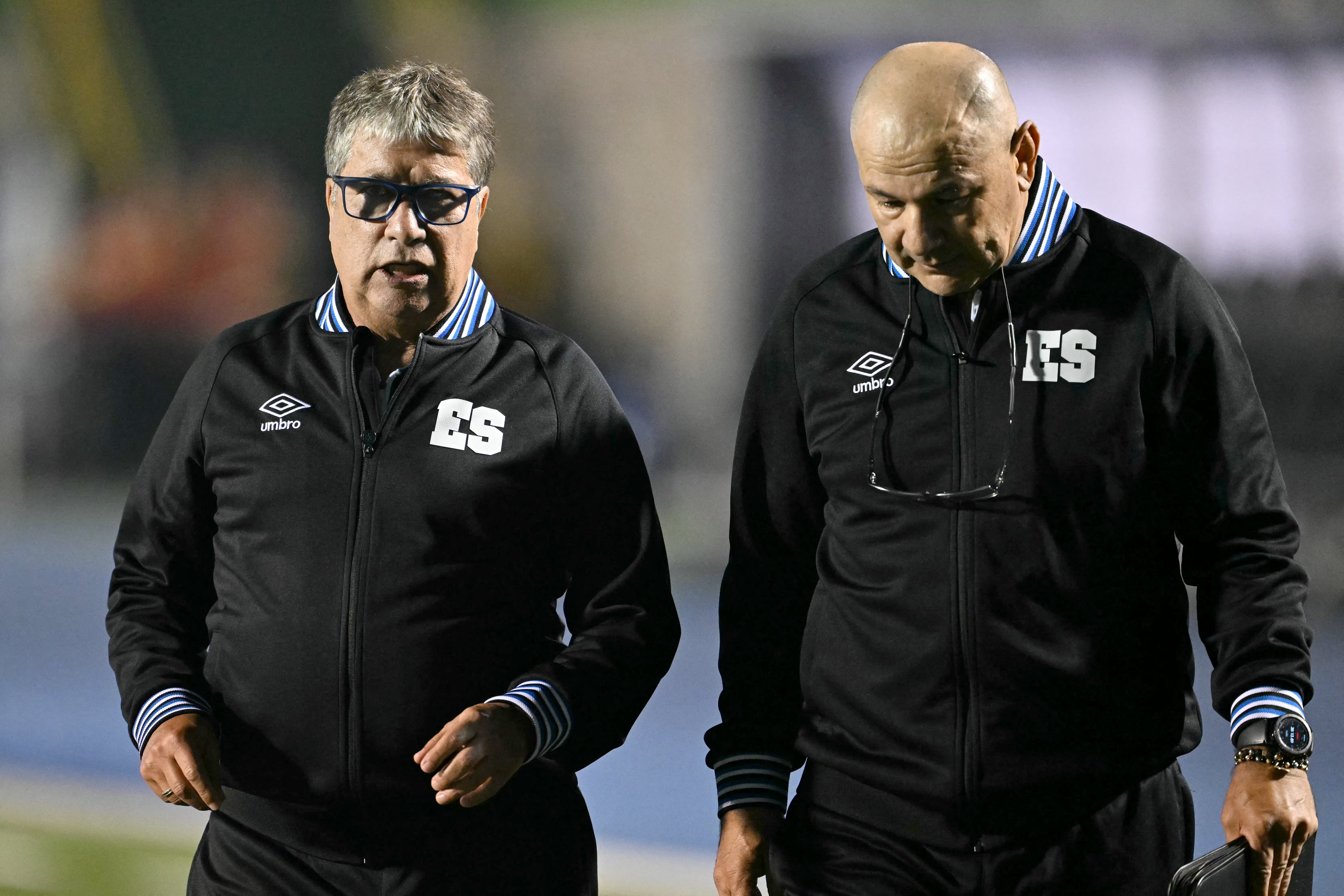 El entrenador colombiano de El Salvador, Hernán Darío 'Bolillo' Gómez (izq.), y el entrenador asistente colombiano, Edgar Carvajal (der.), gesticulan durante el partido de clasificación de la CONCACAF para la Copa Mundial de la FIFA 2026 entre Guatemala y El Salvador en el estadio Cementos Progreso de la ciudad de Guatemala el 4 de septiembre de 2025. (Foto de Johan ORDÉZ / AFP)