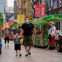 Personas que usan mascarillas para ayudar a frenar la propagación del coronavirus caminan en trenes de juguete a lo largo de una calle comercial en Shanghai, China, el lunes 23 de agosto de 2021 (AP Photo / Andy Wong).