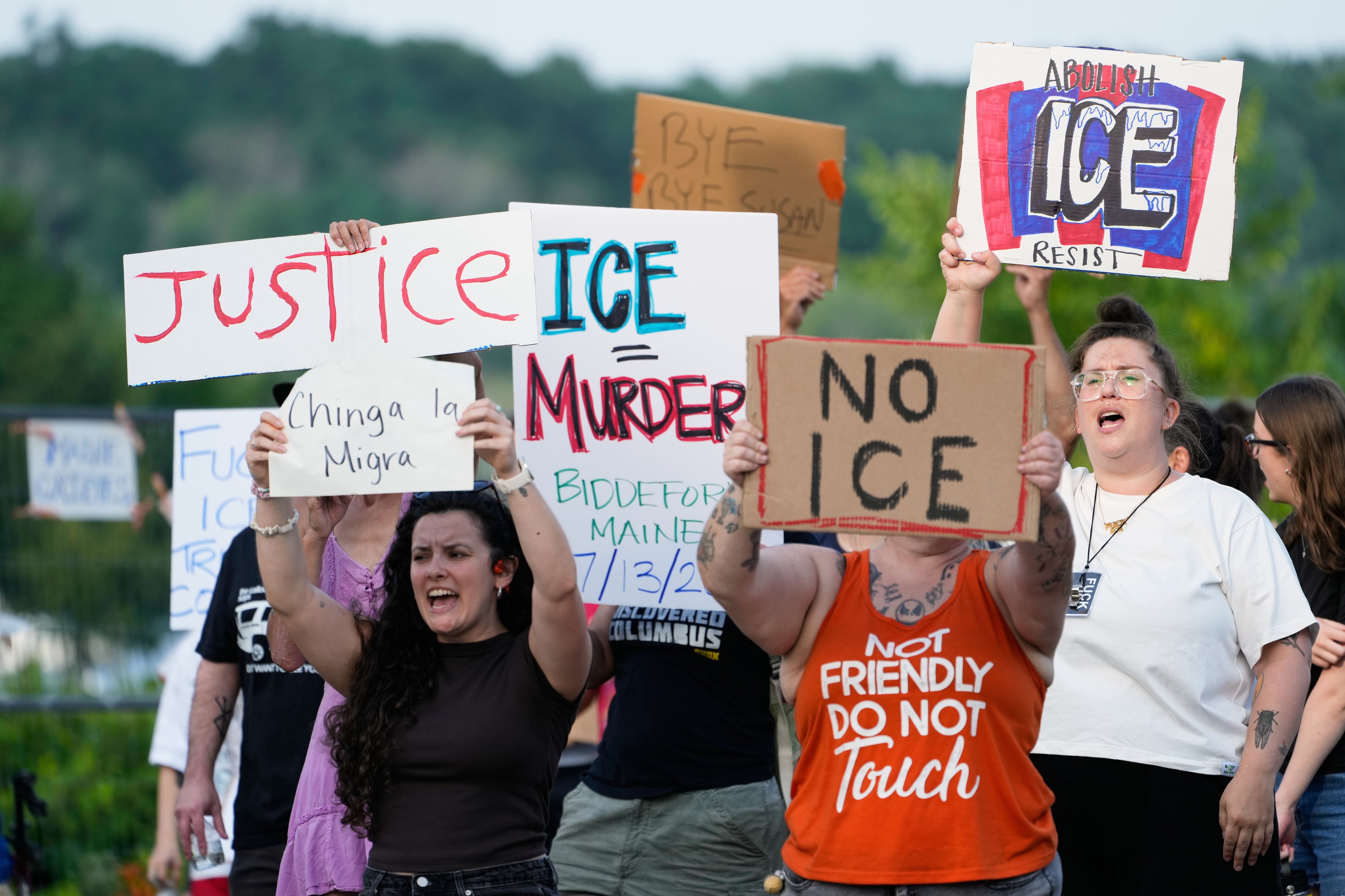 Manifestantes portan pancartas después de que un hombre fuera abatido a tiros por el Servicio de Inmigración y Control de Aduanas de EE. UU. en Biddeford, Maine.