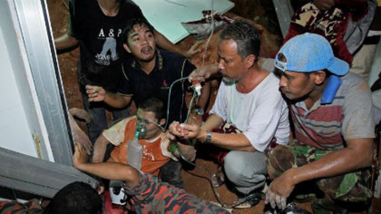 Bomberos y rescatistas ayudan a un herido del deslizamiento en Hulu Langat, en las afueras de Kuala Lumpur (Malasia).