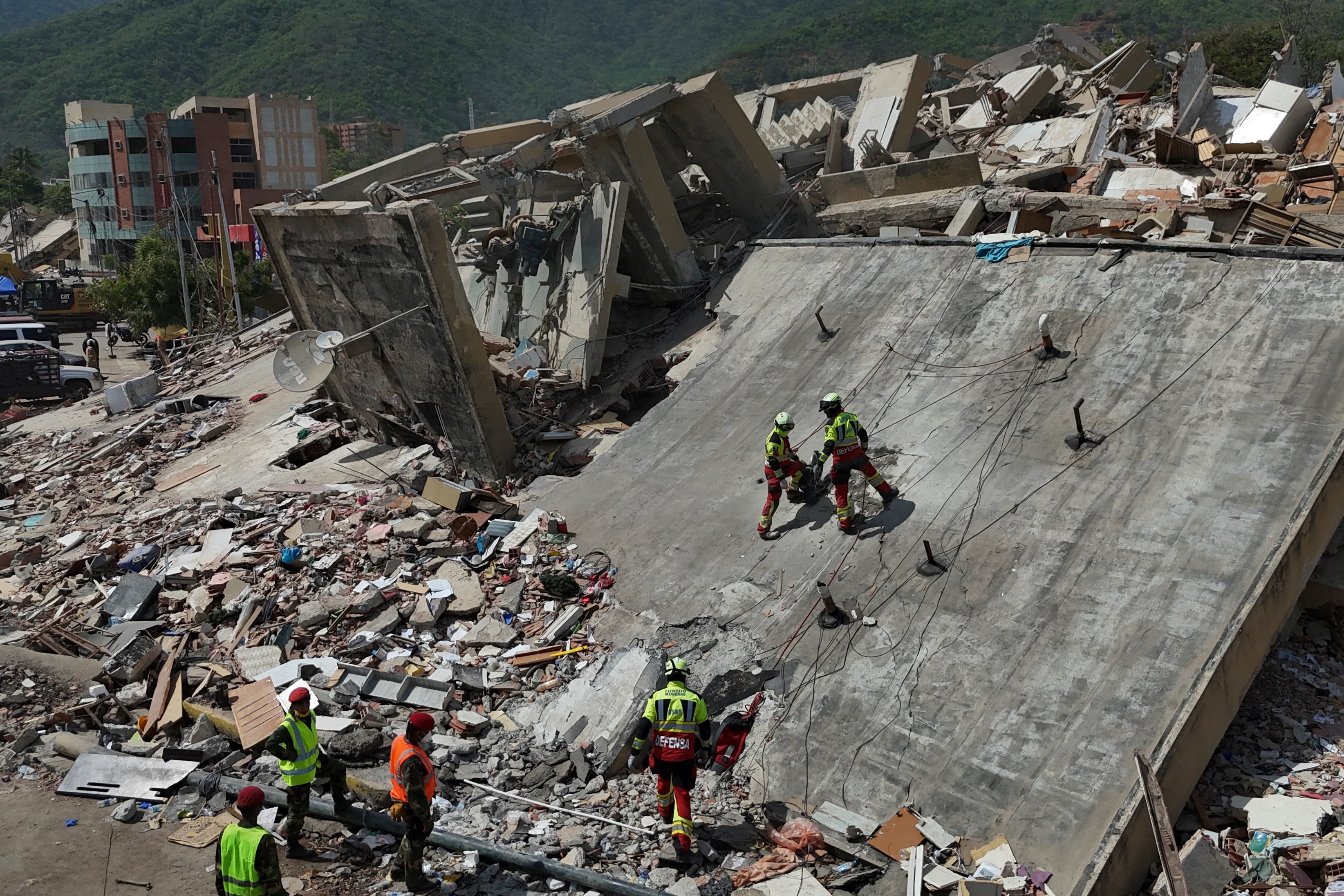 Equipos de rescate del Ejército mexicano buscan a personas atrapadas en edificios colapsados ​​tras los terremotos que afectaron a La Guaira, Venezuela.
