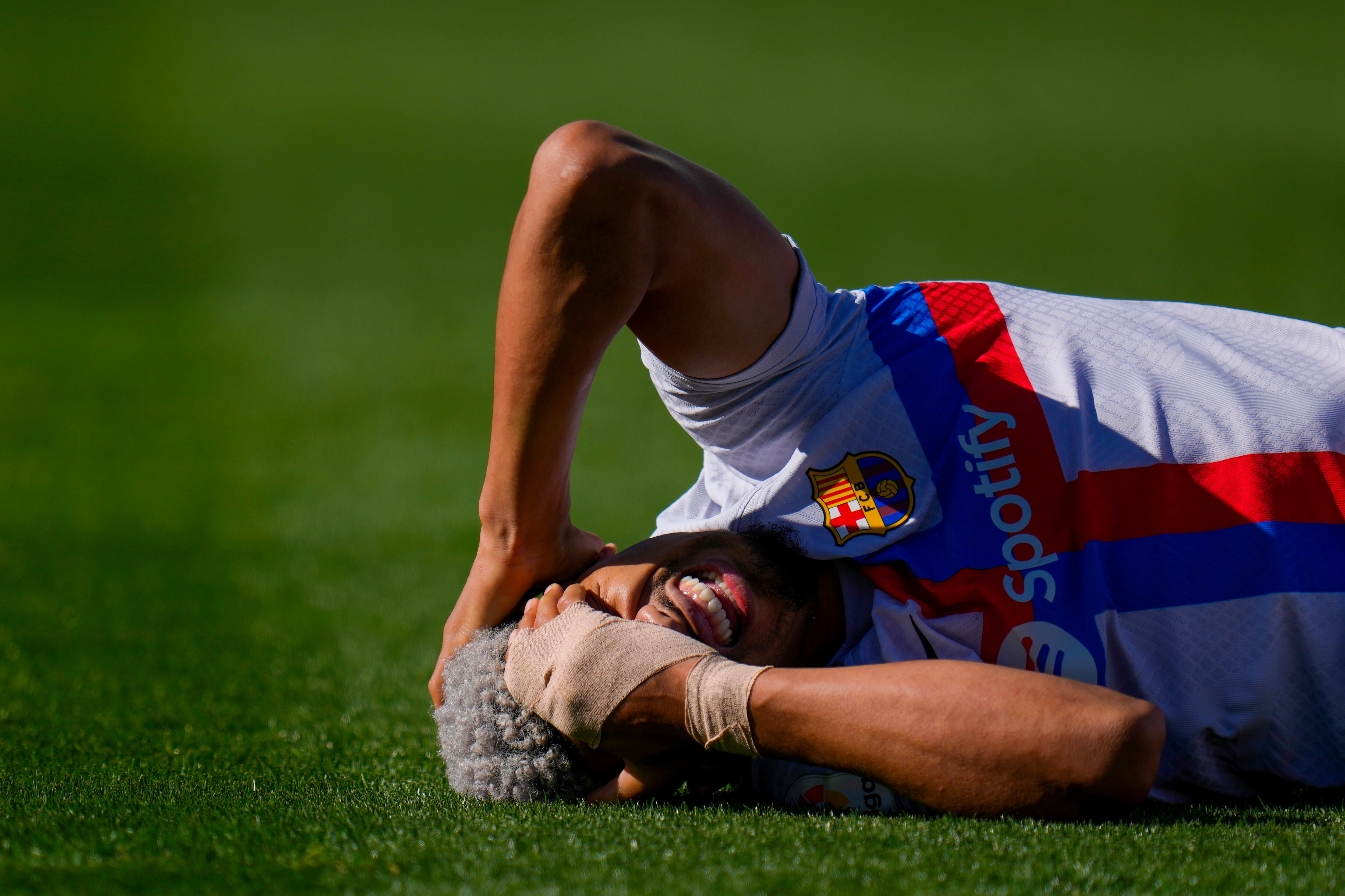 Barcelona's Ronald Araujo grimaces in pain after a tackle during a Spanish La Liga soccer match between Getafe and FC Barcelona at the Coliseum Alfonso Perez stadium in Getafe, Spain, Sunday, April 16, 2023. (AP Photo/Manu Fernandez)