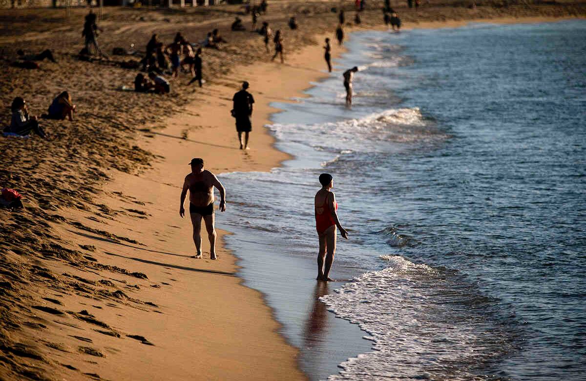 La gente disfruta de la playa en Barcelona, España, miércoles 20 de mayo de 2020. Barcelona permitió a las personas caminar en sus playas el miércoles, por primera vez desde el inicio del virus encierro hace más de dos meses. (Foto AP / Emilio Morenatti)