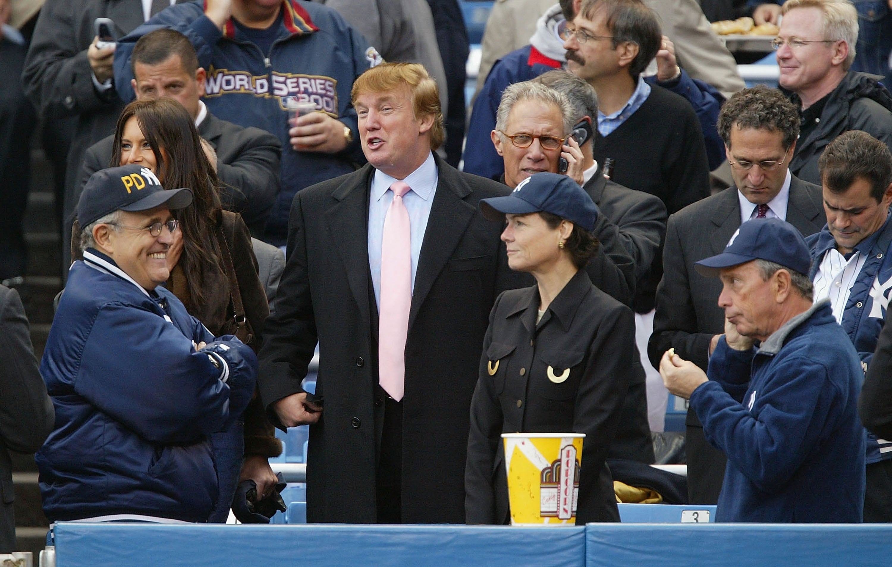 BRONX, NY - OCTOBER 15: Real estate magnate Donald Trump talks with former New York City mayor Rudy Giuliani while current mayor Michael Bloomberg (far R) eats popcorn before the start of game 6 of the American League Championship Series between the Yankees and Boston Red Sox on October 15, 2003 at Yankee Stadium in the Bronx, New York. (Photo by Ezra Shaw/Getty Images)