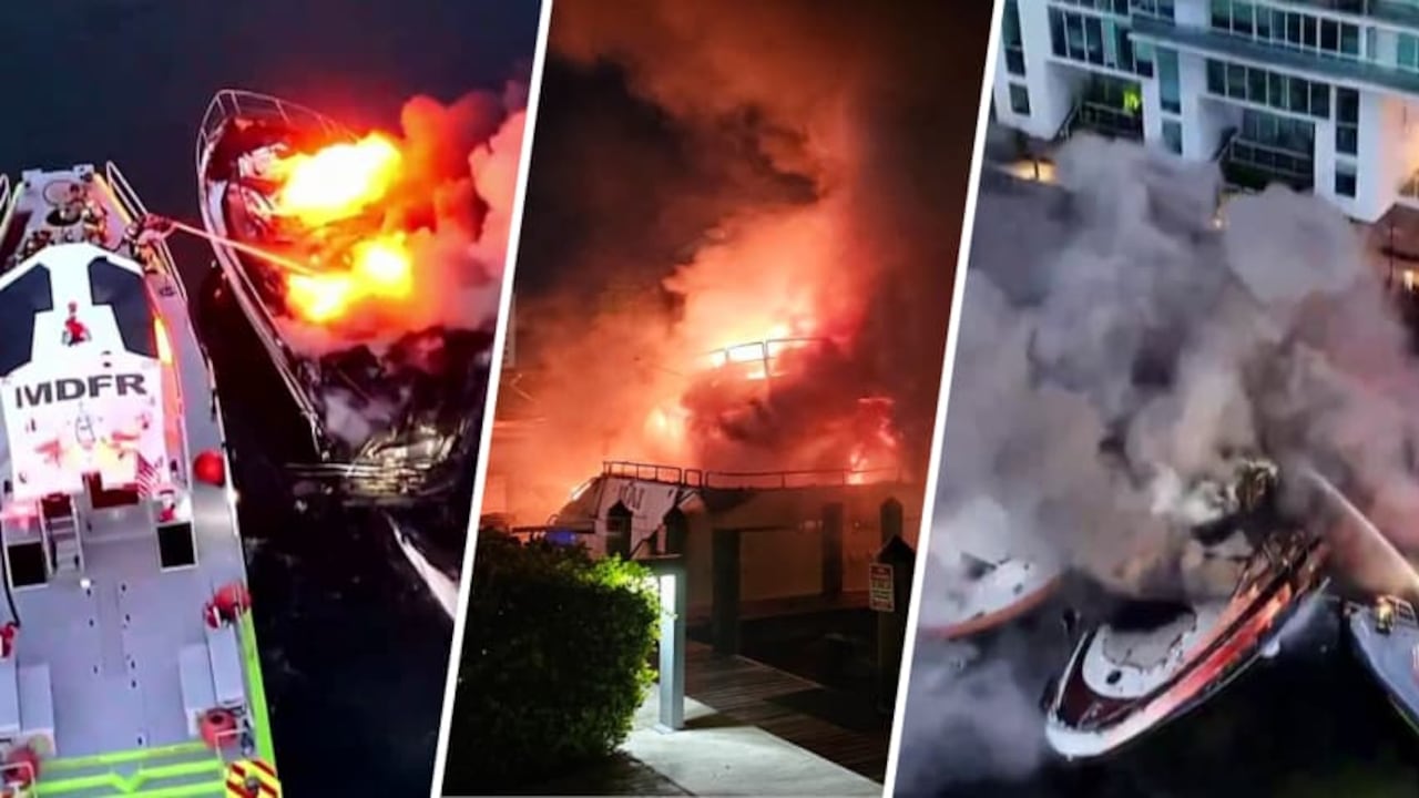 Yates destruidos por el fuego en el muelle de Sunny Isles Beach, con estructuras metálicas retorcidas y cenizas visibles en el agua.