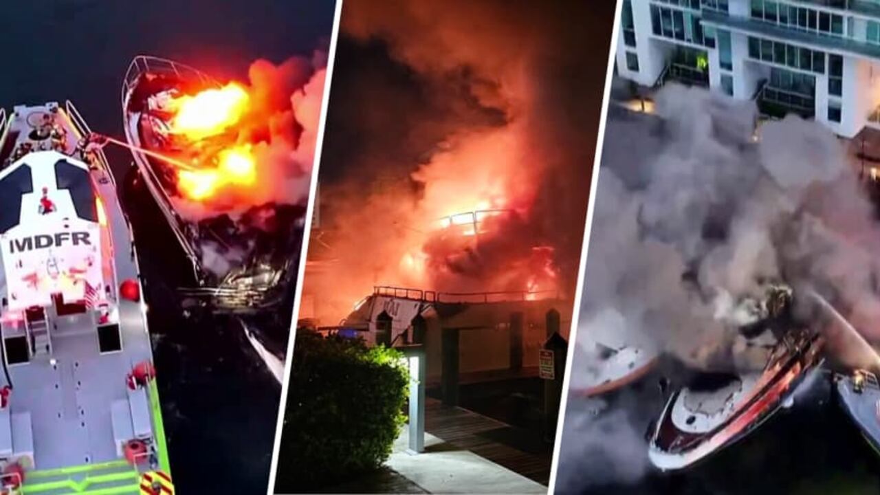 Los restos de las embarcaciones completamente calcinadas permanecen a flote tras ser arrasadas por el fuego en el muelle de Sunny Isles.