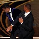 Will Smith, right, hits presenter Chris Rock on stage while presenting the award for best documentary feature at the Oscars on Sunday, March 27, 2022, at the Dolby Theatre in Los Angeles. (AP Photo/Chris Pizzello)