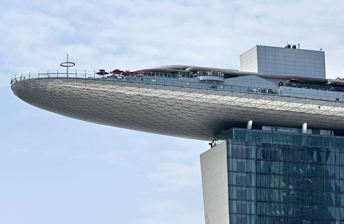 Los visitantes observan desde la cubierta del techo del Marina Bay Sands Skypark, en Singapur, el 29 de agosto de 2019. (Foto por Roslan RAHMAN / AFP)