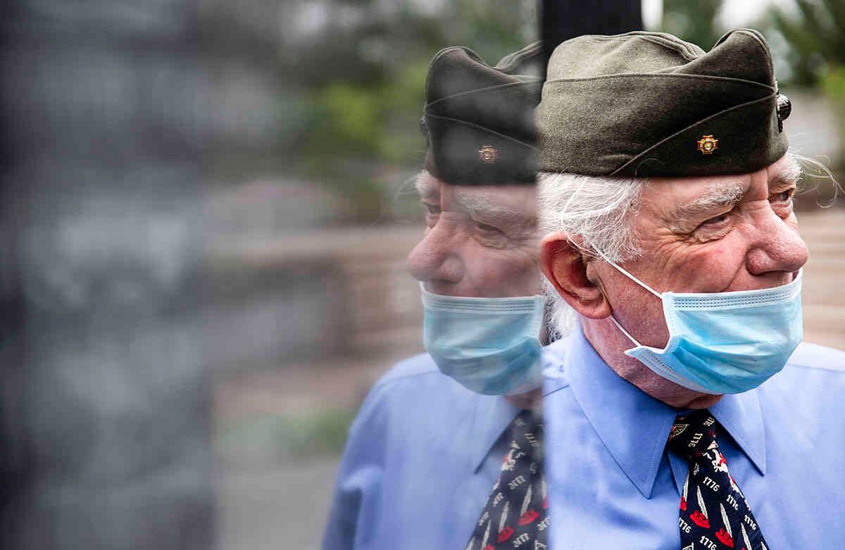 El veterano del Cuerpo de Marinos de los Estados Unidos, John Kline, con un tapabocas protector como precaución contra el coronavirus, presenta sus respetos en el Memorial de la Guerra de Corea, en Filadelfia, el Día de los Caídos, el lunes 25 de mayo de 2020. (Foto AP / Matt Rourke)