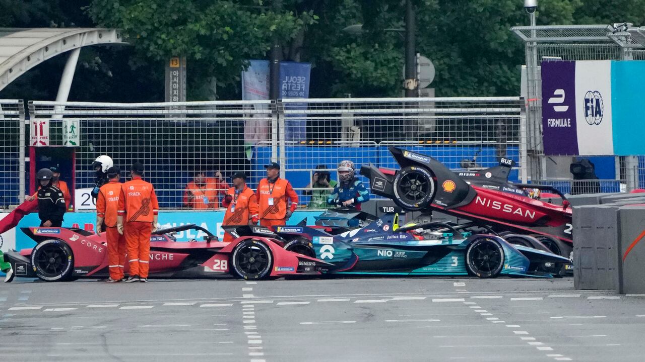 Track marshalls work near the cars of Avalanche Andretti Formula E's driver Oliver Askew of the U.S., 28, Nio 333 Formula E Team's driver Oliver Turvey of Britain, 3, and Nissan e.dams' driver Sebastien Buemi of Switzerland, 23, after they crashed during the Seoul E-Prix Formula E auto race round 15 in Seoul, South Korea, Saturday, Aug. 13, 2022. (AP Photo/Lee Jin-man)