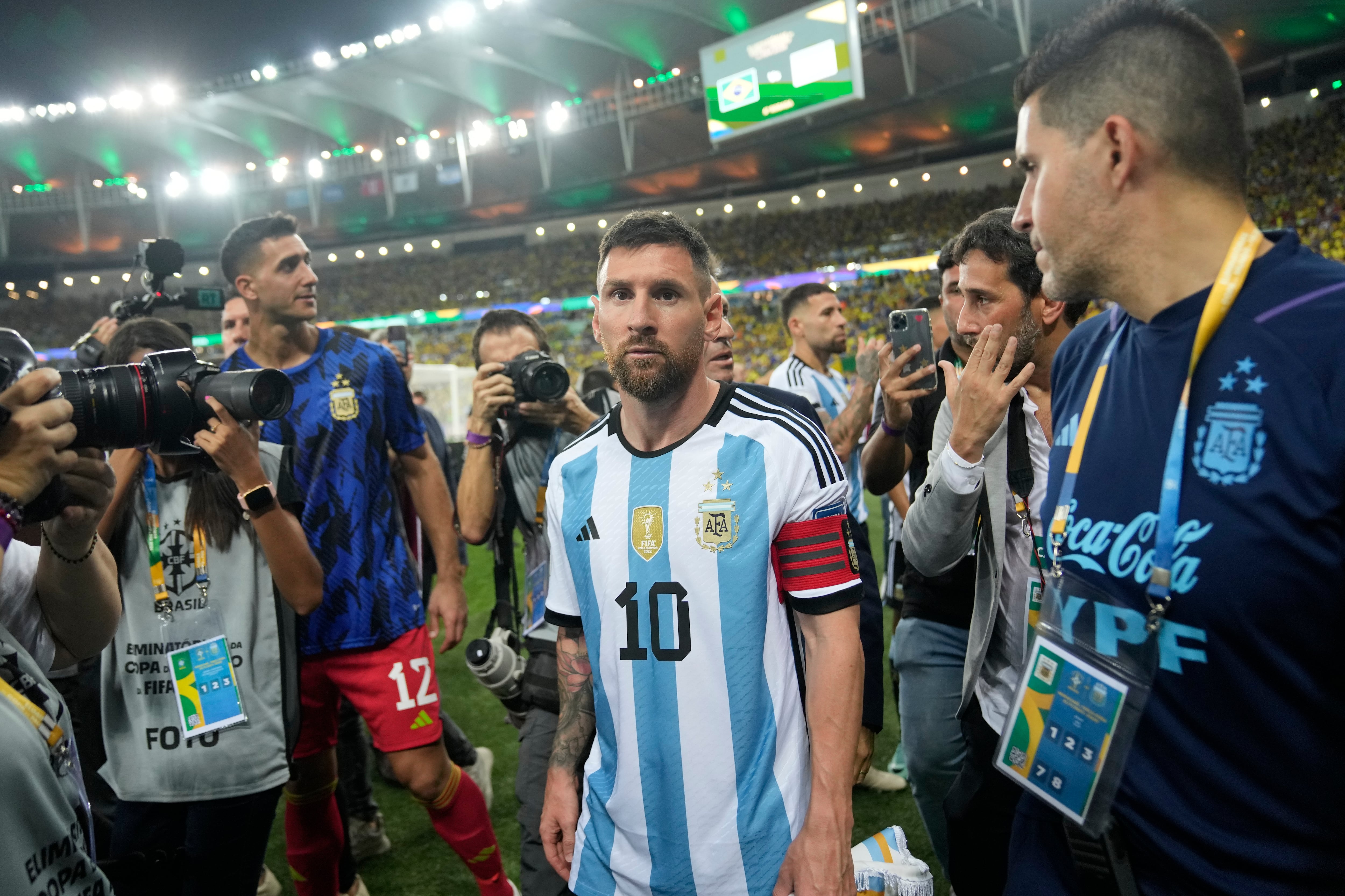 El delantero argentino Lionel Messi se marcha de la cancha tras una riña entre hinchas, previa al partido de la eliminatoria mundialista ante Brasil en el Maracaná, el martes 21 de noviembre de 2023. (AP Foto/Silvia Izquierdo)