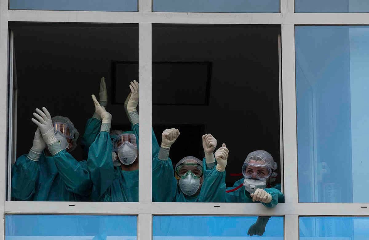 Trabajadores de la salud reaccionan a los aplausos de las personas en apoyo a quienes trabajan día y noche para hacer frente al brote del virus covid-19, en el hospital universitario de la Fundación Jiménez Díaz, en Madrid, España, el 15 de abril. España ha suavizado esta semana las condiciones del cierre más estricto de Europa, permitiendo la fabricación, la construcción y otras actividades no esenciales en un intento por amortiguar el impacto económico de la pandemia. Foto: Manu Fernández/ AP