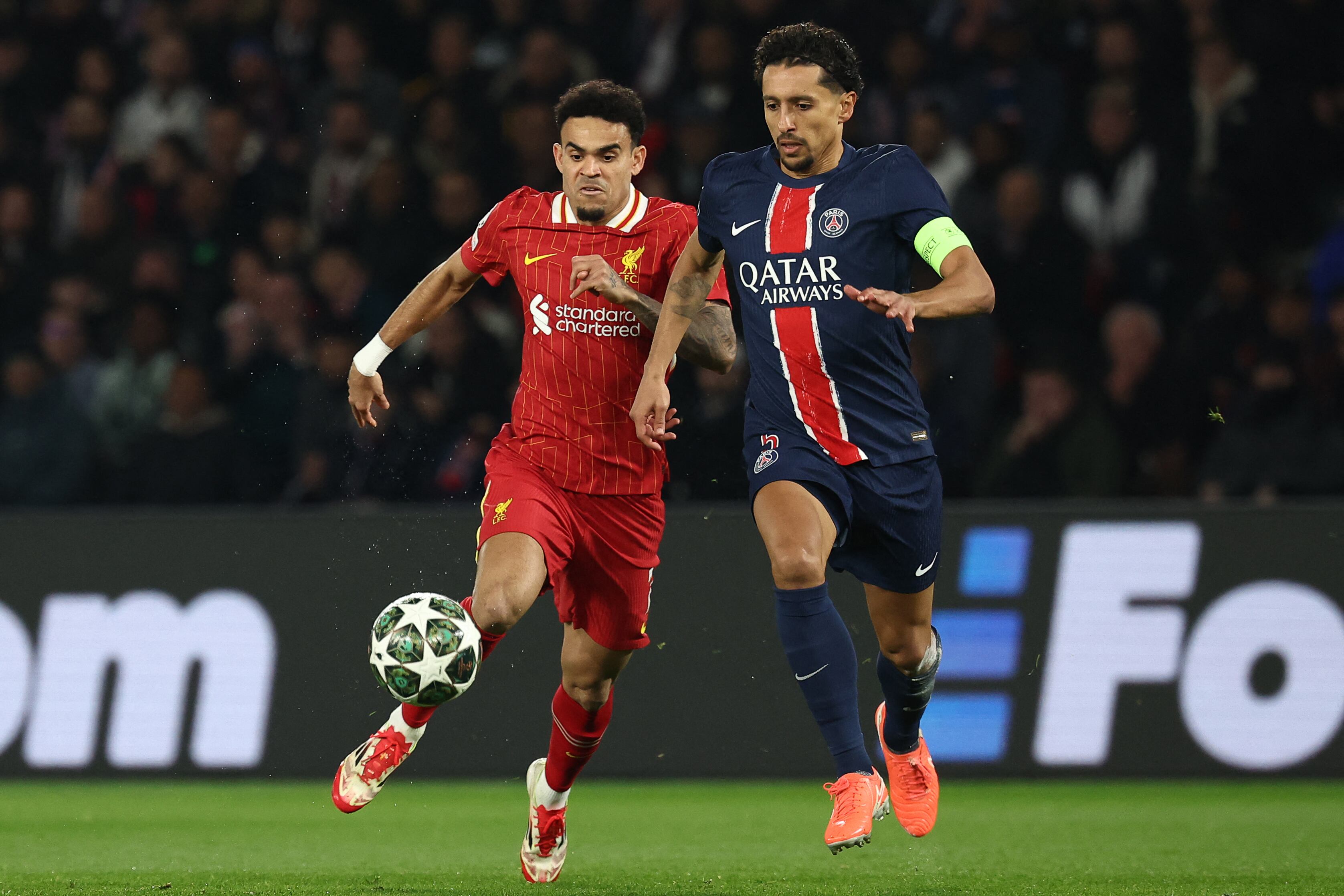 Paris Saint-Germain's Brazilian defender #05 Marquinhos (R) and Liverpool's Colombian forward #07 Luis Diaz (L) fight for the ball during the UEFA Champions League Round of 16 first leg football match between Paris Saint-Germain (FRA) and Liverpool (ENG) at the Parc des Princes stadium in Paris on March 5, 2025. (Photo by Anne-Christine POUJOULAT / AFP)