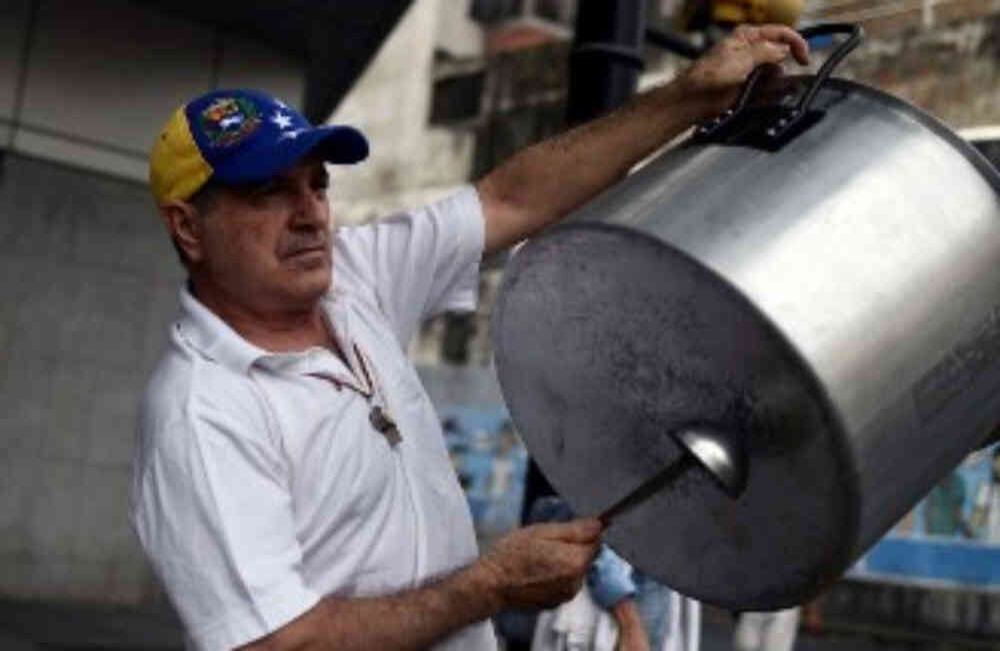 Un opositor alienta a los manifestantes con el sonido de una olla. Crédito:  FEDERICO PARRA / AFP