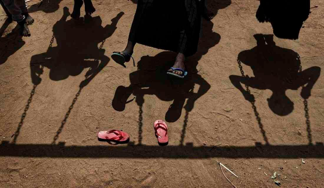 Los niños refugiados sudaneses juegan en columpios durante el almuerzo en el patio de la guardia Ombechi (Foto de AP / Ben Curtis)