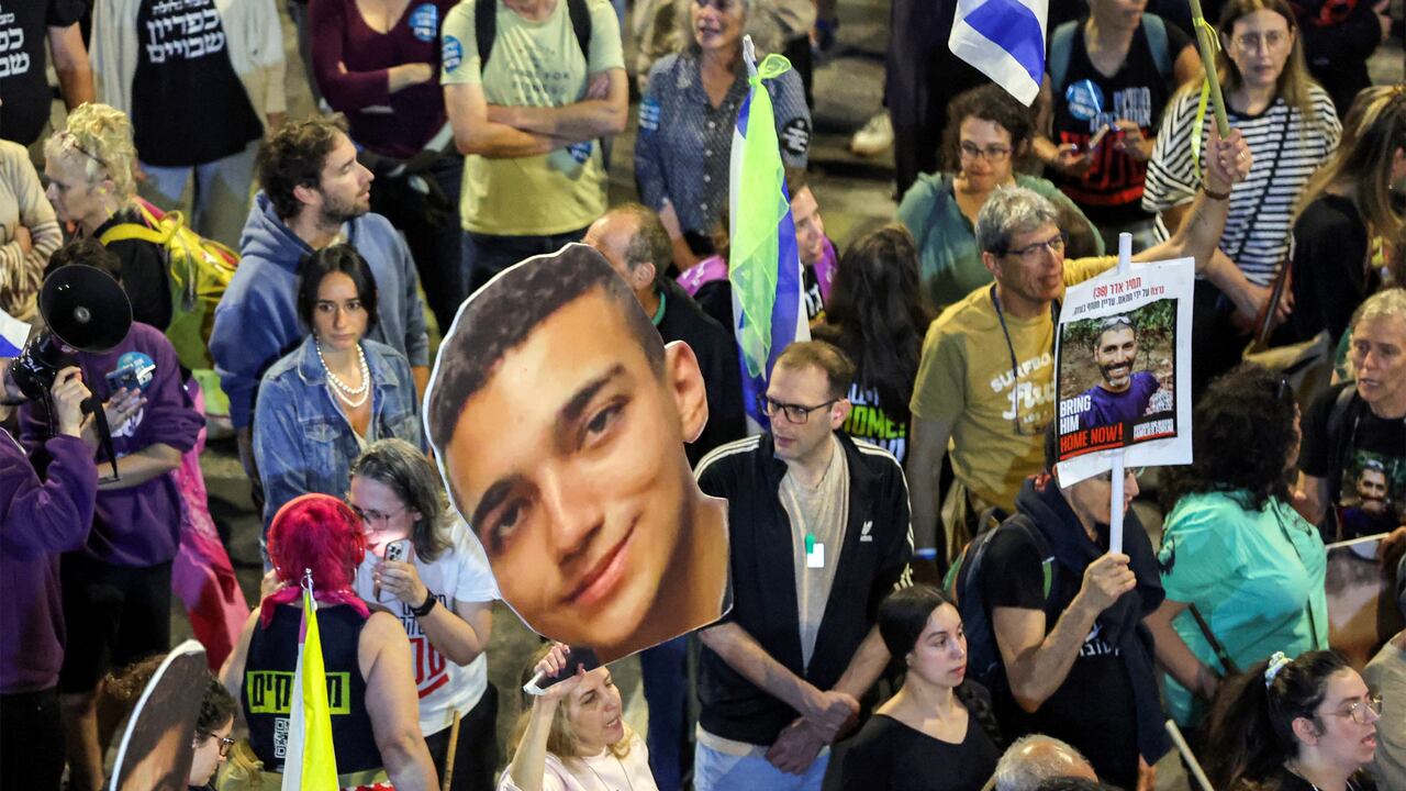 Un manifestante sostiene un cartel con el rostro del rehén estadounidense-israelí Edan Alexander (C) durante una protesta que exige la liberación de los rehenes restantes cautivos en Gaza desde los ataques del 7 de octubre de 2023