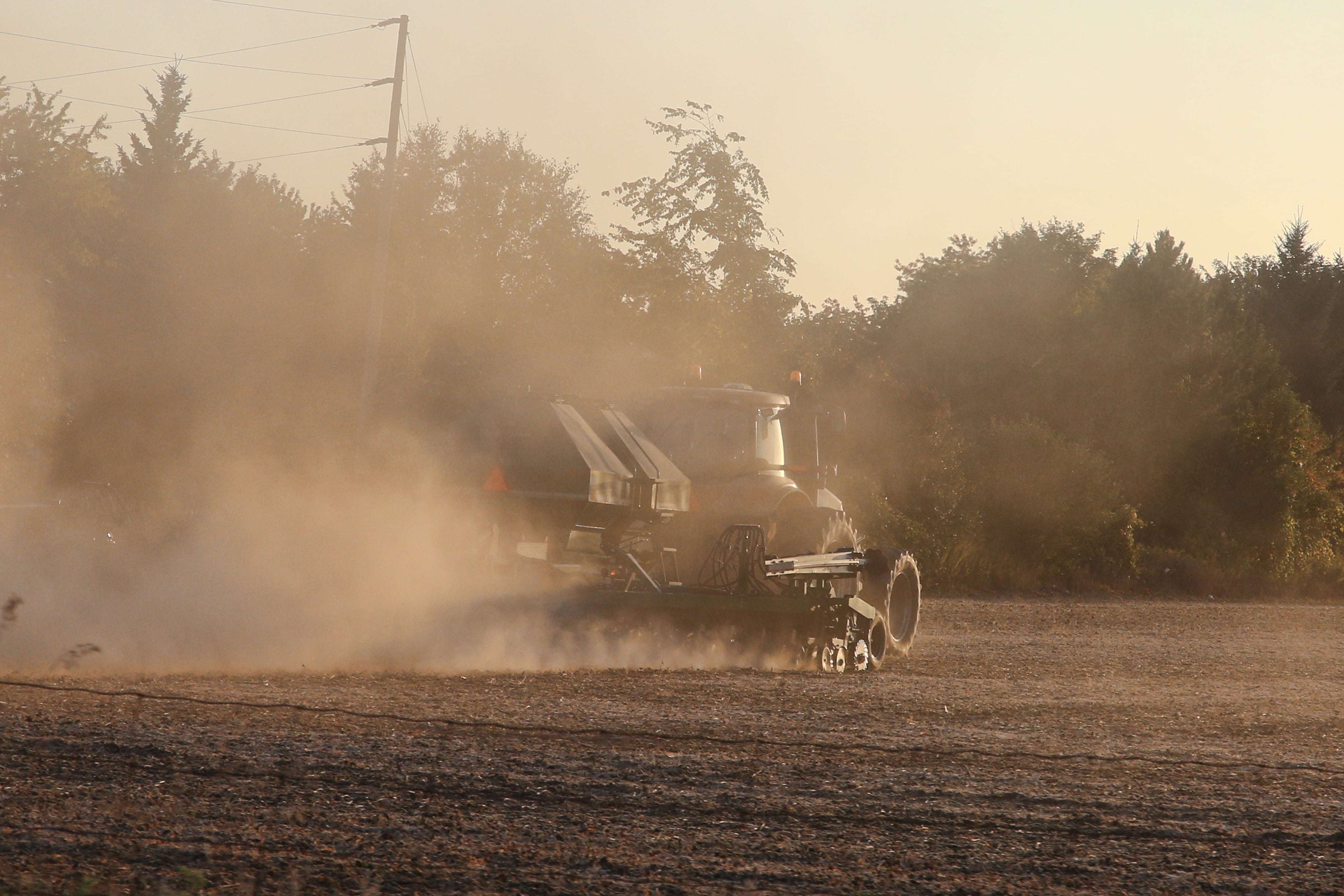 Un granjero utiliza una máquina para labrar tierras de cultivo después de cosechar los cultivos en Innisfil, Ontario, Canadá