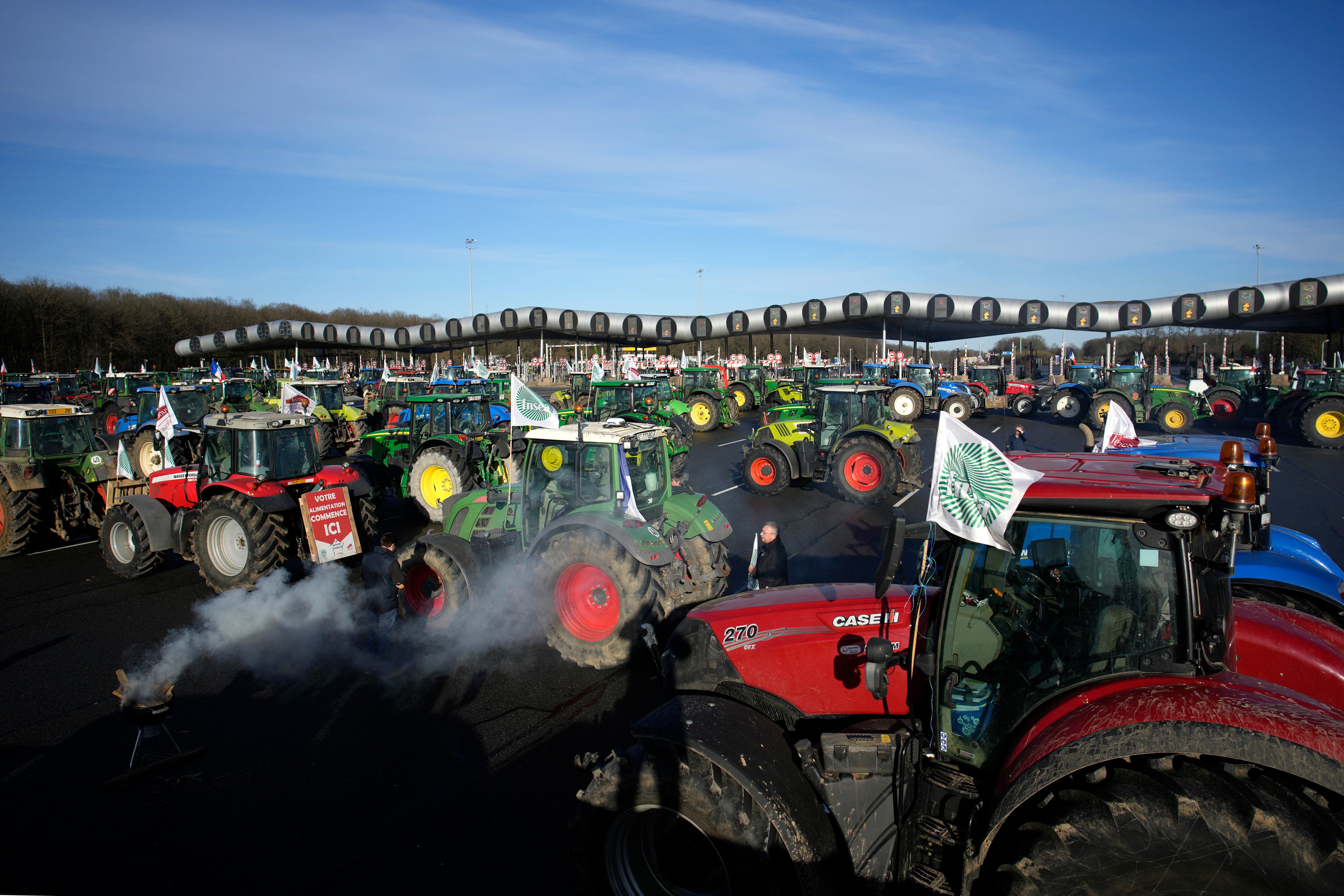 Los agricultores bloquean el peaje de la autopista Saint-Arnoult con sus tractores, el viernes 26 de enero de 2024 en Saint-Arnoult, al sur de París. Los agricultores que protestaban cerraron largos tramos de algunas de las principales autopistas de Francia el viernes, utilizando sus tractores para bloquear y ralentizar el tráfico y presionar cada vez más al gobierno para que ceda a sus demandas de que el cultivo y la cría de alimentos deberían ser más fáciles y lucrativos.