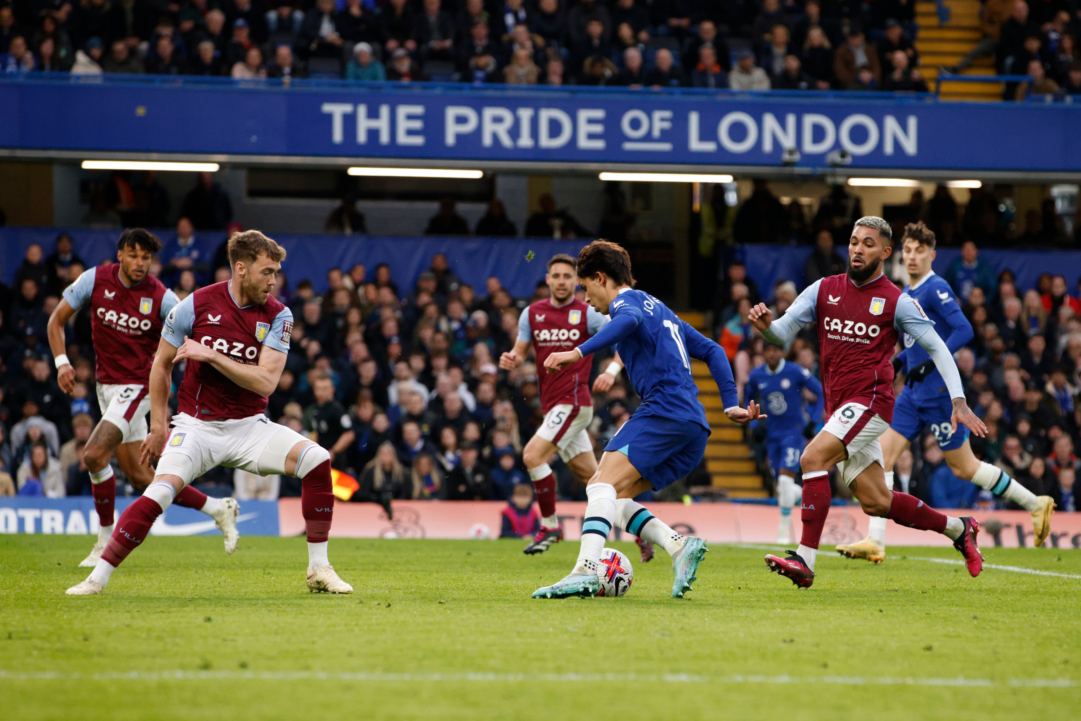 Chelsea's Joao Felix, center, and Aston Villa's Emiliano Buendia, left, vie for the ball during the English Premier League soccer match between Chelsea and Aston Villa at Stamford Bridge stadium in London, Saturday, April 1, 2023. (AP Photo/David Cliff)