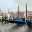 Gondolas are docked along a canal during a low tide in Venice, Italy, Saturday, Feb. 18, 2023. Some of Venice's secondary canals have practically dried up lately due a prolonged spell of low tides linked to a lingering high-pressure weather system. (AP Photo/Luigi Costantini)