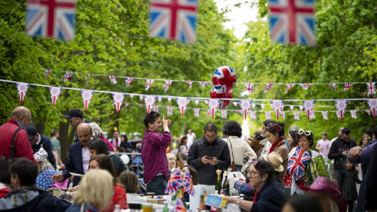 La gente habla y comparte comida durante las celebraciones del Gran Almuerzo en el Regent's Park de Londres, el domingo 7 de mayo de 2023.
