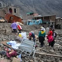 Residentes del aislado pueblo de Camaná, 840 kilómetros al sur de Lima, caminan entre los escombros dejados tras un deslizamiento de tierra en Perú. Las autoridades el lunes, advirtiendo que el número de víctimas del desastre podría aumentar. Los deslizamientos de lodo y rocas surgieron como consecuencia de las lluvias torrenciales. (Photo by Diego Ramos / AFP)