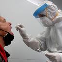 Un empleado de un nuevo centro de pruebas rápidas corona de Lufthansa realiza una prueba de un hombre en el aeropuerto de Múnich, Alemania. to: AP / Matthias Schrader.