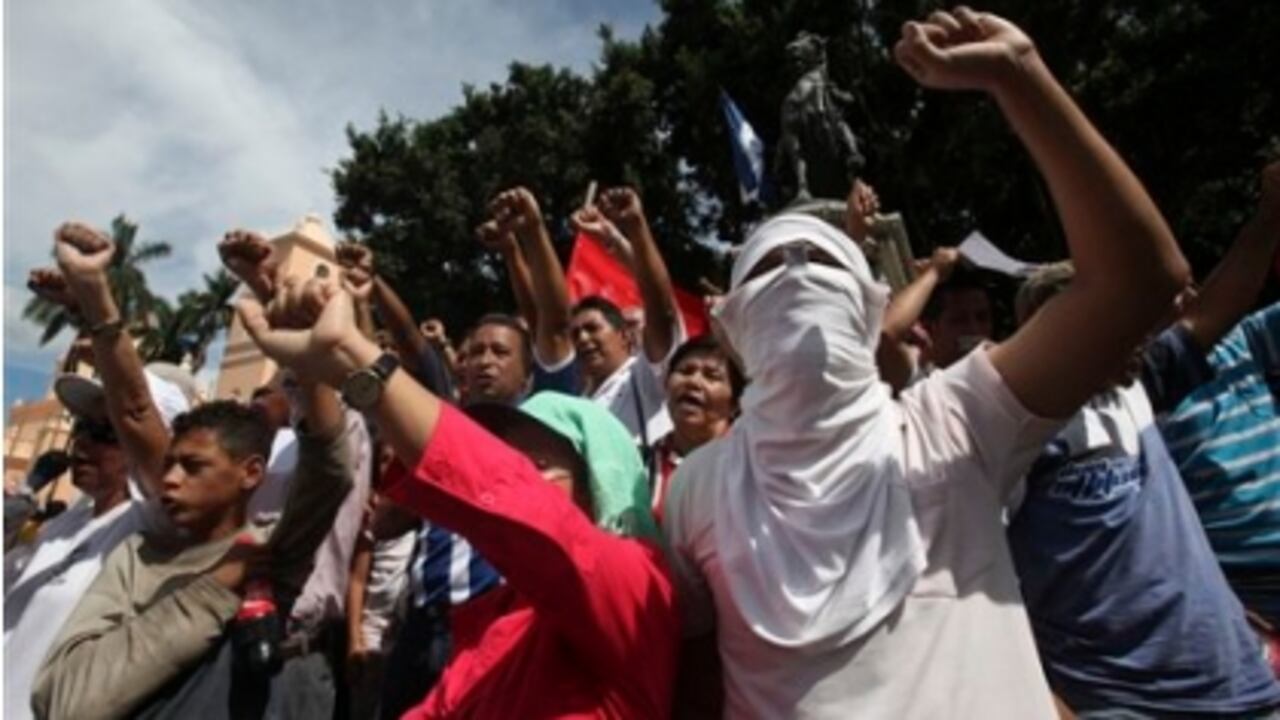 Seguidores del derrocado presidente de Honduras, Manuel Zelaya, levantan los puños, en sus protestas de este miércoles 1 de julio en Tegucigalpa