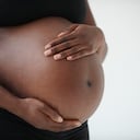 Midsection of pregnant Black woman holding belly