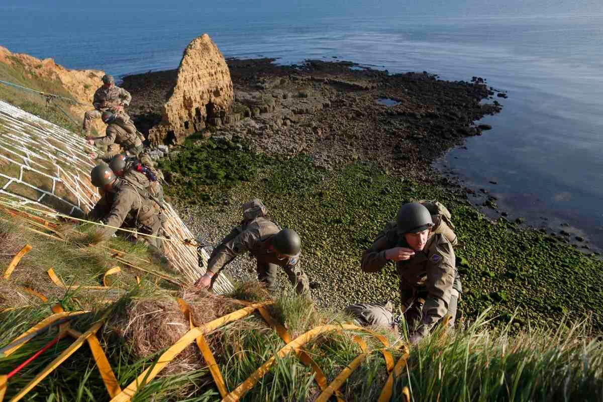  5 de junio - Soldados del Regimiento Ranger número 75 de EE. UU. -vestidos de época- escalan el acantilado de Pointe-du-Hoc en Cricqueville-en-Bessin, Normandía para representar la hazaña que hicieron el 6 de junio de 1944, cuando ese mismo regimiento escaló 100 pies para apoderarse de piezas de artillería alemana que podrían haber disparado a las tropas de desembarco estadounidenses. Fotógrafo: Thibault Camus /AP