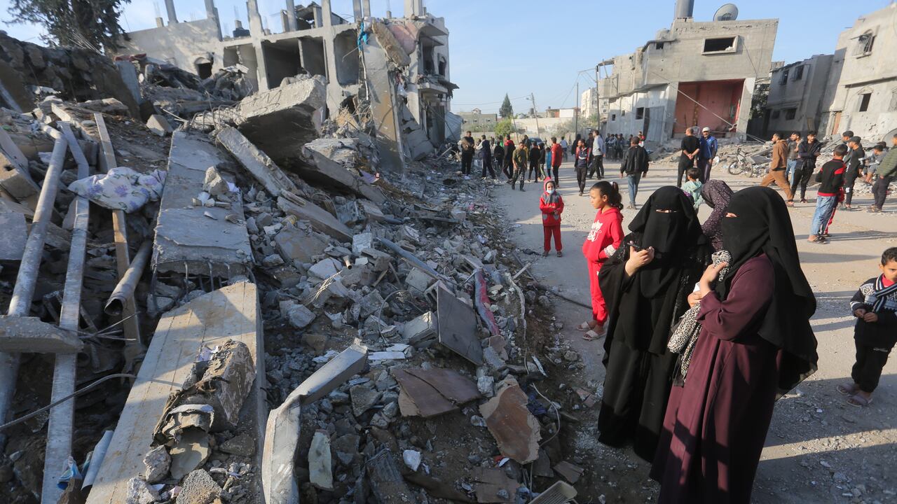 Palestinos observan la destrucción causada por el bombardeo israelí de la Franja de Gaza en Rafah