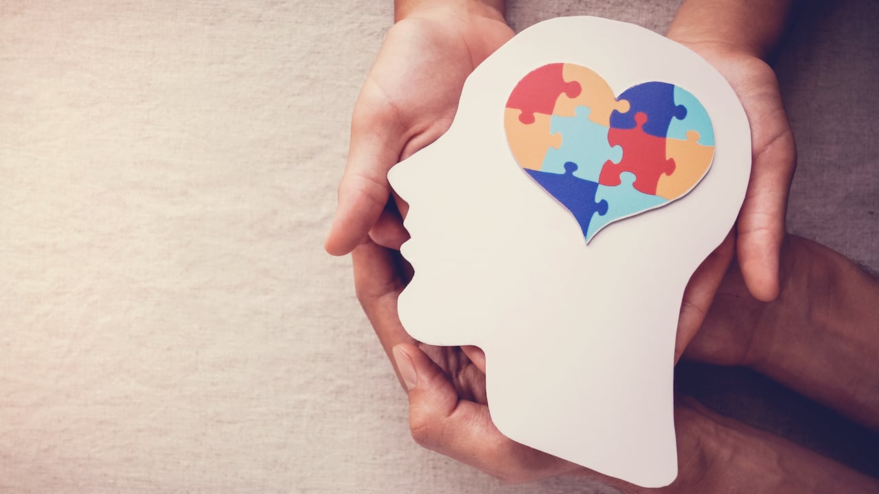 Rompecabezas corazón en el cerebro, concepto de salud mental, día mundial de concientización sobre el autismo