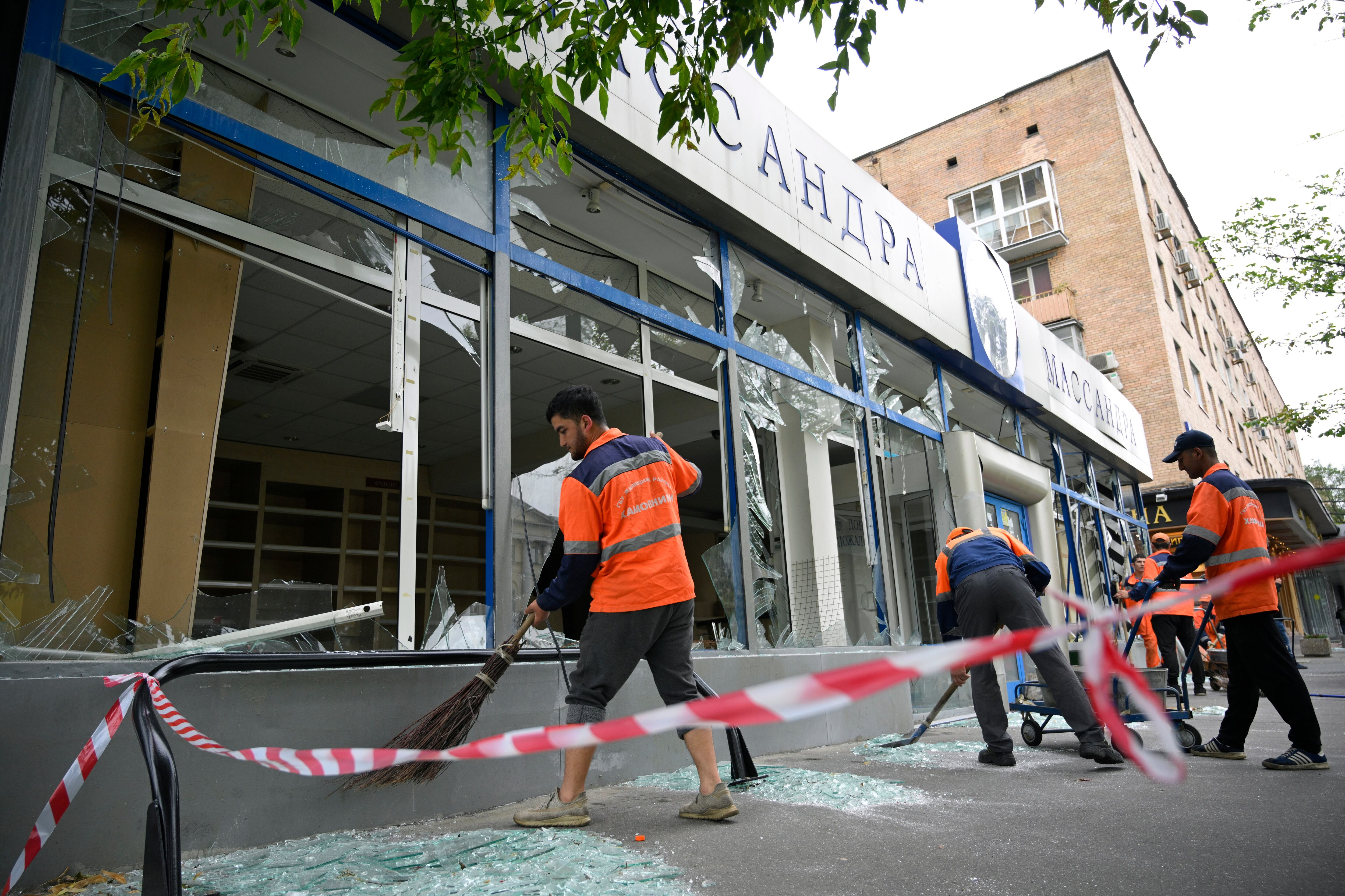 Trabajadores barren vidrios rotos en un edificio dañado luego de un ataque con drones en Moscú, Rusia, el lunes 24 de julio de 2023.