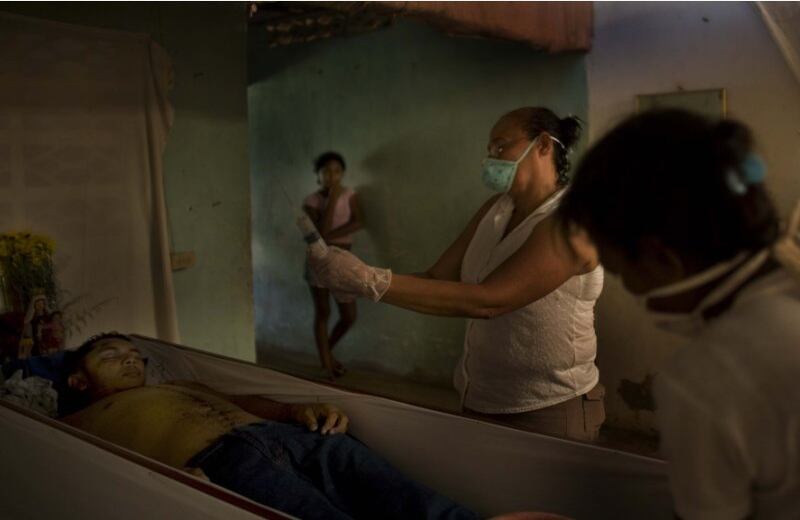 “Les preguntaba por él a los muertos de Riohacha, a los muertos que llegaban del Valle de Upar, a los que llegaban de la ciénaga, y nadie le daba razón, porque Macondo fue un pueblo desconocido para los muertos hasta que llegó Melquíades y lo señaló con un puntito negro en las abigarrados mapas de la muerte.” (“Cien Años de Soledad”) - El cuerpo de un joven asesinado es preparado por sus propios familiares para su sepelio en Carmen de Bolívar, Martes, Julio16, 2009.