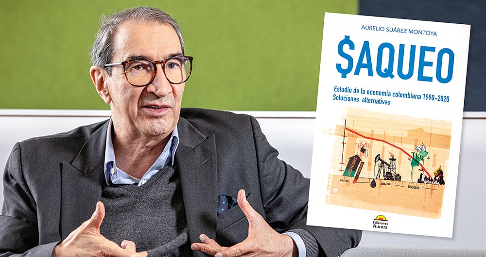 Señor de edad con traje y lentes siendo entrevistado.