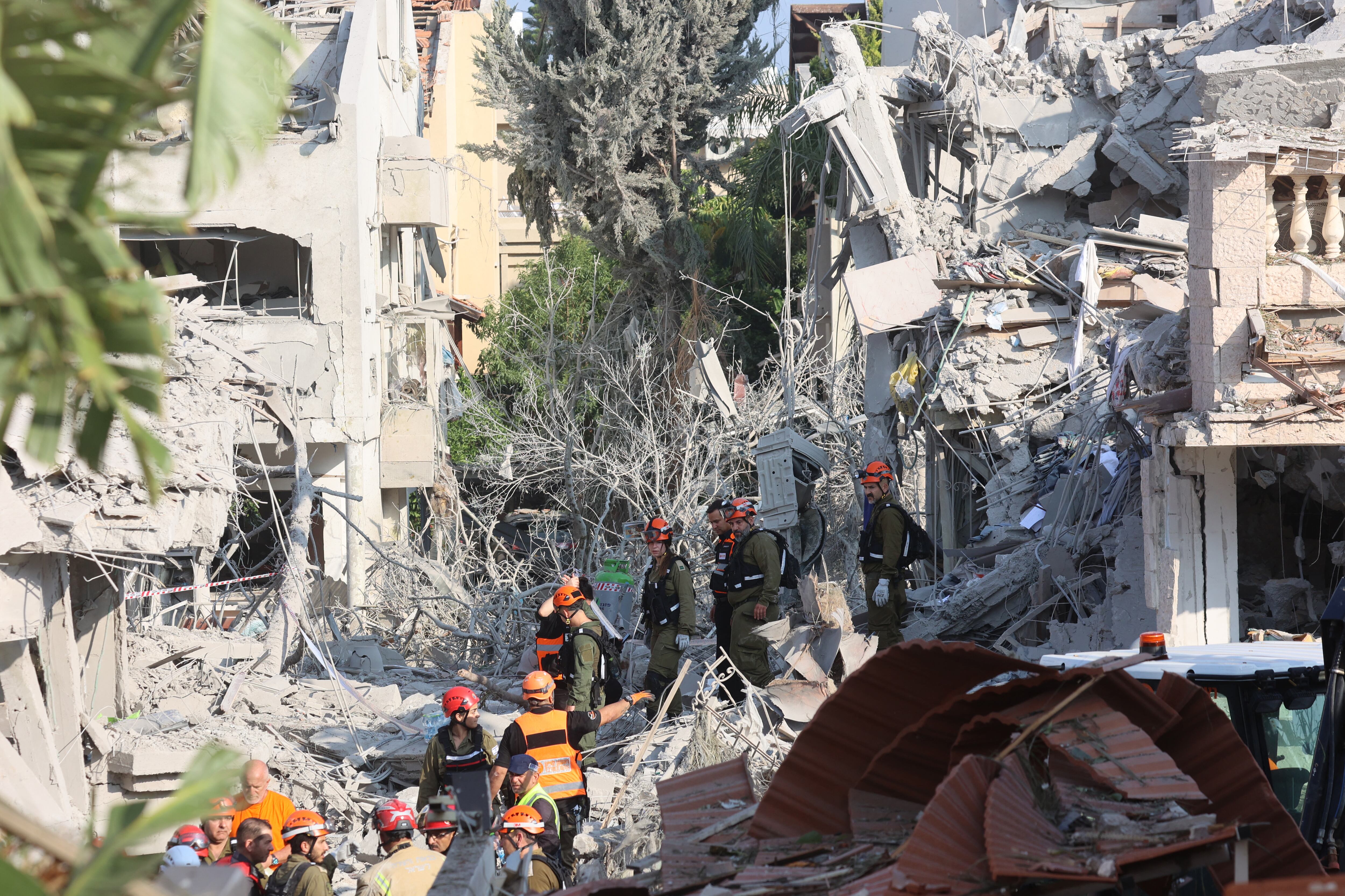 Israeli emergency responders inspect a site hit by a missile fired from Iran near Tel Aviv on June 14, 2025. Iran struck Israel early June 14, with barrages of missiles after a massive onslaught targeted the Islamic republic's nuclear and military facilities, and killed several top generals. (Photo by GIL COHEN-MAGEN / AFP)