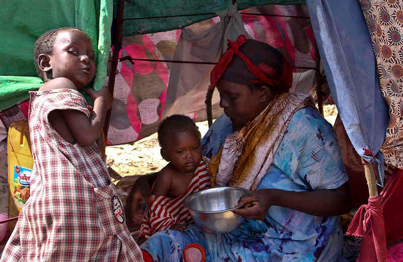 Una mujer se desplazó con sus hijos en su refugio improvisado en un campamento en el área de Garasbaley, en las afueras de Mogadiscio, Somalia (Foto del AP / Farah Abdi Warsameh)  