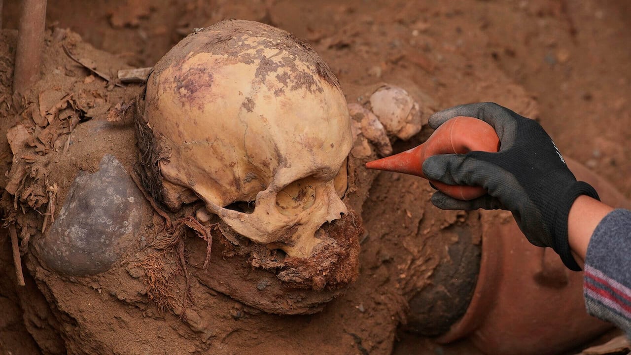 El arqueólogo José Aliaga trabaja en el lugar donde fueron hallados restos óseos, presuntamente de la cultura preincaica Chancay, durante la excavación de una línea de gas natural en Puente Piedra, Lima, Perú, el jueves 31 de julio de 2025.